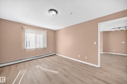 Spacious room featuring wood-finish flooring and a neutral color palette - 