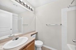 Bathroom featuring a single vanity with an oval basin, a large wall mirror, and a toilet - 