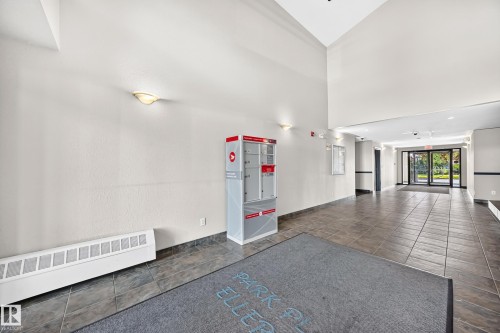 Spacious entryway featuring tile flooring and sconce lighting - #317 245 Edwards Dr Sw, Edmonton, AB - Indoor Photo Showing Other Room
