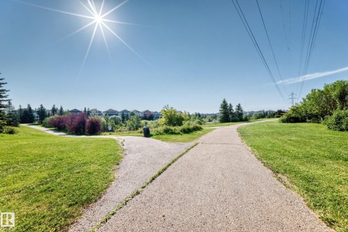 Paved pathways winding through green spaces with mature trees and landscaping - #317 245 Edwards Dr Sw, Edmonton, AB - Outdoor With View