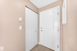 Entryway featuring a white paneled door with brushed nickel hardware, and an adjacent bifold closet door - 