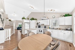 Spacious kitchen with white cabinetry, stainless steel appliances, and a central island - 