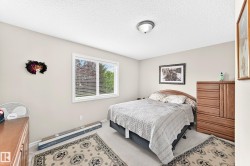 Spacious bedroom featuring light-colored walls, a window with blinds, and carpeted flooring - 