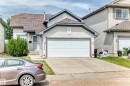 Two-story residence featuring light-toned siding, a multi-pane garage door, and a brown shingle roof - 3226 30 Avenue Nw, Edmonton, AB  - Outdoor 