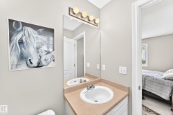 Vanity with an integrated sink and laminate countertop, framed by a wall-mounted mirror with a four-bulb vanity light fixture - 