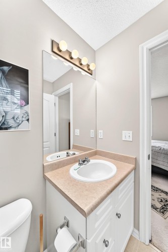 Bathroom vanity featuring a single basin sink, laminate countertop, and white cabinetry with silver-tone hardware - 3226 30 Avenue Nw, Edmonton, AB - Indoor Photo Showing Bathroom