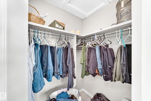 Built-in closet system featuring white shelving and chrome hanging rods - 3226 30 Avenue Nw, Edmonton, AB - Indoor With Storage
