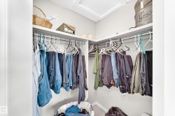 Built-in closet system featuring white shelving and chrome hanging rods - 