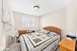 Bedroom featuring a single window with blinds, a wood-finish headboard, and an overhead flush-mount light fixture - 