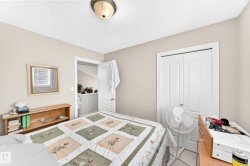 Bedroom featuring light neutral wall paint, white trim, a semi-flush mount ceiling light, and a double-door closet - 