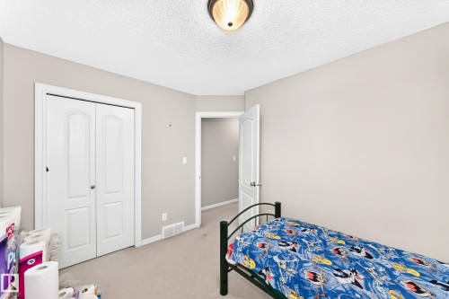 Carpeted room with light neutral wall paint and a textured ceiling - 3226 30 Avenue Nw, Edmonton, AB - Indoor Photo Showing Bedroom