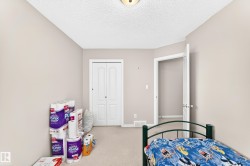 Interior room featuring light neutral wall paint, textured ceiling, and neutral carpeting - 