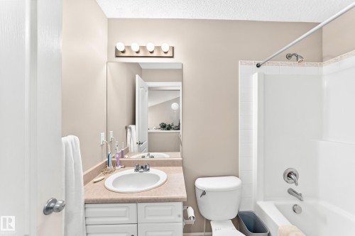 Bathroom featuring a vanity with a drop-in sink, beige countertop, and white cabinetry - 3226 30 Avenue Nw, Edmonton, AB - Indoor Photo Showing Bathroom