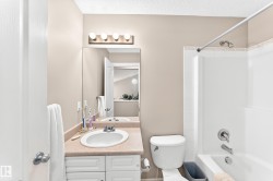Bathroom featuring a vanity with a drop-in sink, beige countertop, and white cabinetry - 