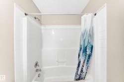Tub/shower combination featuring a bright white surround, brushed nickel fixtures, and a shower head - 