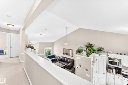 Open-concept living space featuring vaulted ceilings, light neutral wall paint, and white trim - 