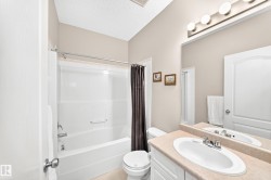 Bathroom featuring a white tub/shower combination, a vanity with an integrated sink, a large mirror, and overhead lighting - 