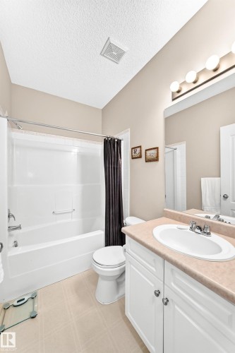 Full bathroom featuring a single white vanity with a light-toned countertop, a tub/shower combination, and light-colored flooring - 3226 30 Avenue Nw, Edmonton, AB - Indoor Photo Showing Bathroom