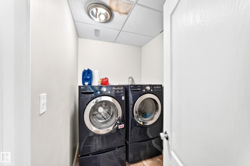 Dedicated laundry area featuring a front-loading washer and dryer set - 3226 30 Avenue Nw, Edmonton, AB - Indoor Photo Showing Laundry Room