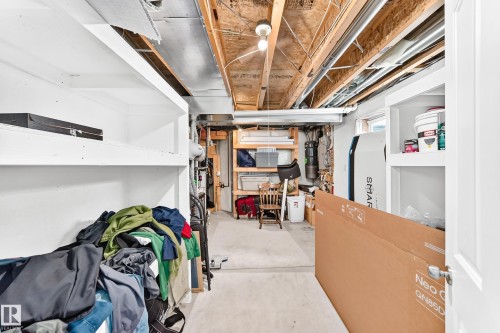 Utility space featuring exposed ceiling joists, open shelving, a concrete floor, and interior lighting - 3226 30 Avenue Nw, Edmonton, AB - Indoor Photo Showing Basement