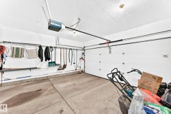 Attached garage featuring a white overhead door and concrete flooring - 