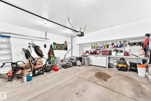 Spacious garage with concrete flooring, built-in shelving, white walls, and track lighting - 3226 30 Avenue Nw, Edmonton, AB - Indoor Photo Showing Garage