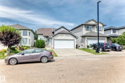 Light-toned siding exterior with an attached garage and a concrete driveway - 