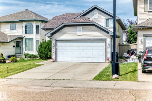 Two-story residential exterior with light-colored horizontal siding and dark trim - 3226 30 Avenue Nw, Edmonton, AB - Outdoor