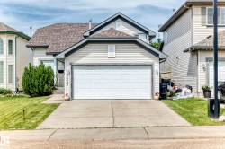 Exterior featuring a two-car garage with a concrete driveway, a front walkway, and a manicured lawn - 