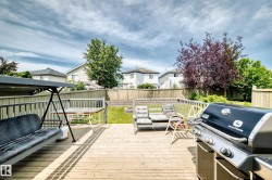 Expansive wood deck with railing overlooking a fenced backyard - 