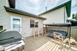 Expansive wood-finish deck with white vinyl siding exterior - 