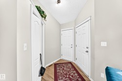 Entryway featuring light neutral wall paint, wood-finish flooring, and white trim work - 