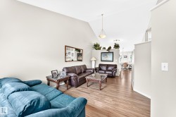 Spacious living area featuring vaulted ceilings, wood-finish flooring, and recessed lighting - 