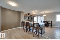 Open-concept kitchen and dining area with wood-finish flooring - 