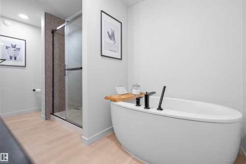 Freestanding soaking tub with matte black fixtures - 8047 227 Street Nw, Edmonton, AB - Indoor Photo Showing Bathroom