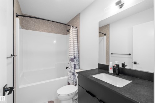 Bathroom featuring a white tub and shower combination with dark bronze fixtures - 8047 227 Street Nw, Edmonton, AB - Indoor Photo Showing Bathroom