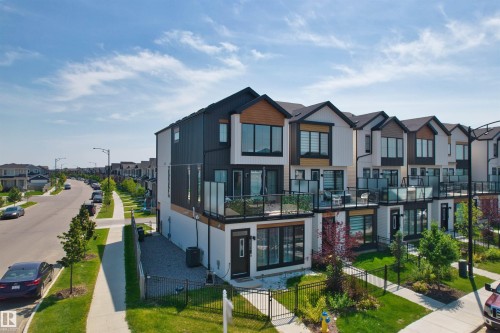Contemporary townhome featuring a black and white facade with natural wood accents - 8047 227 Street Nw, Edmonton, AB - Outdoor With Facade
