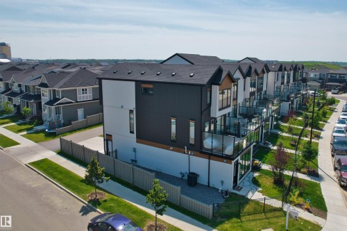 Modern townhome featuring a black and white exterior with wood-finish accents - 8047 227 Street Nw, Edmonton, AB - Outdoor