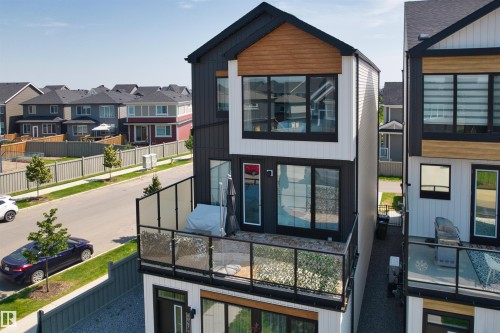 Contemporary facade featuring black vertical siding, white horizontal siding, and natural wood-tone accents - 8047 227 Street Nw, Edmonton, AB - Outdoor With Balcony
