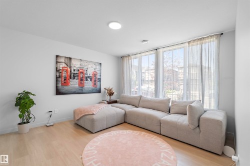 Bright living space with wood-finish flooring, ample natural light from multiple windows, and recessed ceiling lighting - 8047 227 Street Nw, Edmonton, AB - Indoor Photo Showing Living Room