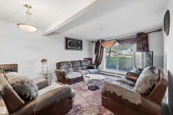 Living room featuring a sliding glass door, overhead semi-flush mount light fixture, and white painted walls - 