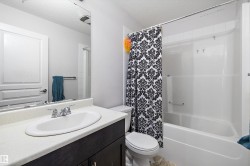 Bathroom featuring a white integrated sink with a chrome faucet, a dark wood-finish vanity, and a full-width mirror - 