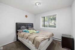 Room featuring a window with blinds, wall-mounted light fixture, and carpeted flooring - 