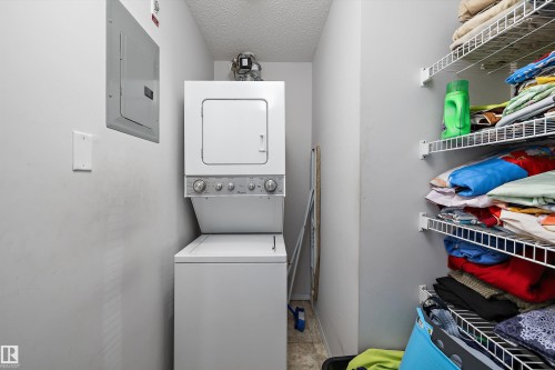 Dedicated laundry area featuring a stacked washer and dryer unit - #143 301 Clareview Station Dr Nw, Edmonton, AB - Indoor Photo Showing Laundry Room