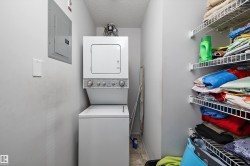 Dedicated laundry area featuring a stacked washer and dryer unit - 