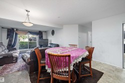 Open-concept living space featuring a dining area with tile flooring and a living room with carpet - 