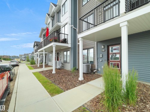 Multi-story exterior featuring a mix of horizontal siding, white trim, and dark metal balcony railings - #81 6905 25 Av Sw, Edmonton, AB - Outdoor With Balcony