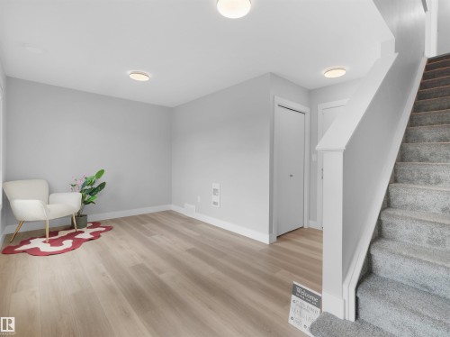 Room featuring wood-finish flooring, light grey painted walls, and white baseboards - #81 6905 25 Av Sw, Edmonton, AB - Indoor Photo Showing Other Room