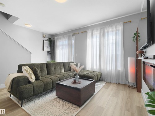 Living area with light wood-finish flooring, light gray walls, and recessed lighting - #81 6905 25 Av Sw, Edmonton, AB - Indoor Photo Showing Living Room