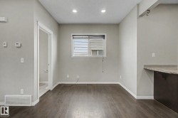 Open concept living space featuring wood-finish flooring, recessed lighting, and neutral wall tones - 